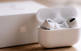 AirPods Pro im geöffneten Ladecase neben einem Apple-Gerät