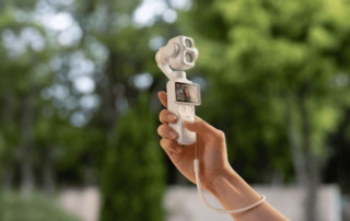 DJI Osmo Pocket 4P Pearl White in der Hand vor grünem Hintergrund